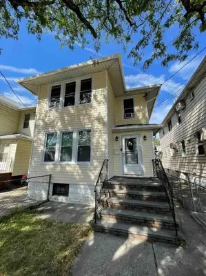 a white house with stairs in front of it at Entire Beautiful 2BR Apartment [L]. Convenient location in the heart of Queens! in Whitestone