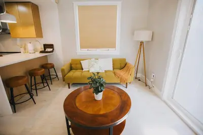 a living room with a yellow couch and a table at Villa Costello, in Kingston