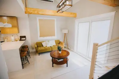 a living room with a yellow couch and a table at Villa Costello, in Kingston