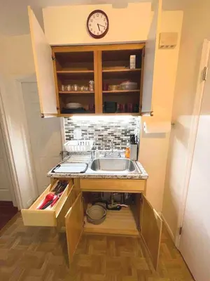 a kitchen with a sink and a clock on the wall at Entire Beautiful 2BR Private Apartment [R] in Whitestone