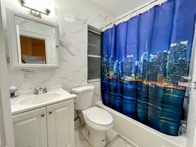 a bathroom with a toilet and a shower curtain at Entire Beautiful 2BR Private Apartment [R] in Whitestone