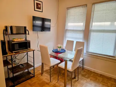a dining room with a table and chairs and a microwave at Entire Beautiful 2BR Private Apartment [R] in Whitestone