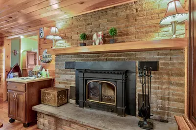 a fireplace in a living room with a brick wall at Lakeview Retreat in Lakeville