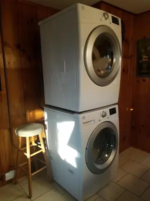 a washer and dryer in a room with a stool at Tory Hill in Hillsdale