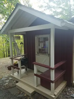 a small cabin with a porch and a table at Tory Hill in Hillsdale