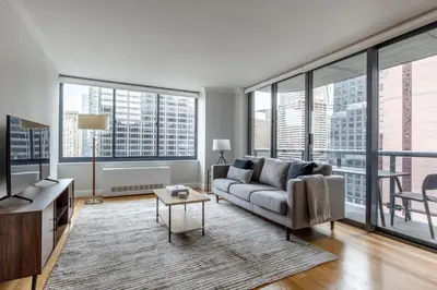 a living room with a couch and large windows at Midtown 1br w doorman wd nr Times Square NYC-1351 in New York