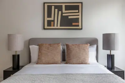 a bedroom with a white bed with two lamps at Midtown 1br w doorman wd nr Times Square NYC-1351 in New York