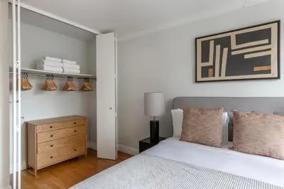 a bedroom with a bed and a dresser and a mirror at Midtown 1br w doorman wd nr Times Square NYC-1351 in New York