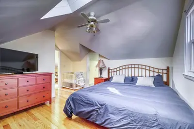 a bedroom with a bed and a ceiling fan at Family Home near NY Beach - Private Workspace in Glen Head