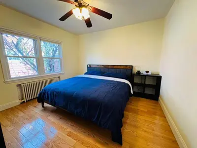 a bedroom with a bed and a ceiling fan at Family Home near NY Beach - Private Workspace in Glen Head