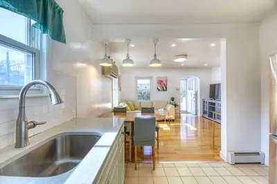 a kitchen with a sink and a living room at Family Home near NY Beach - Private Workspace in Glen Head