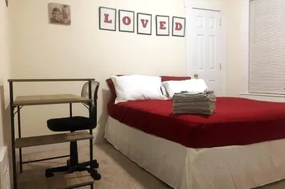 a bedroom with a bed with a red blanket and a chair at Comfy 4 Bed 1 Bath with Wi-fi in College Area in Springfield
