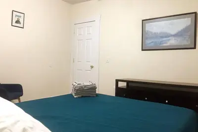 a bedroom with a bed with a blue blanket and a mirror at Comfy 4 Bed 1 Bath with Wi-fi in College Area in Springfield