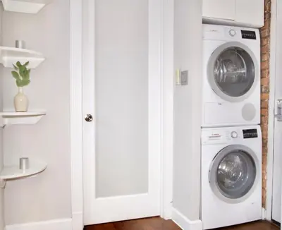 a white laundry room with a washer and dryer at New York Style Stay near Central Park in New York