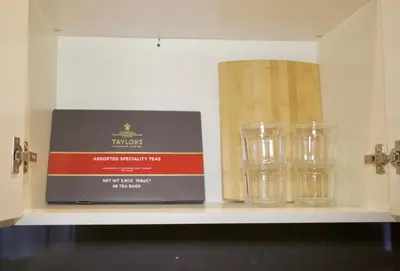 a shelf with three glasses and a box on it at New York Style Stay near Central Park in New York