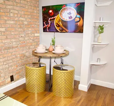 a table with two stools next to a brick wall at New York Style Stay near Central Park in New York