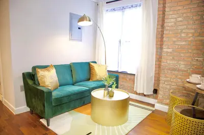 a living room with a green couch and a coffee table at New York Style Stay near Central Park in New York