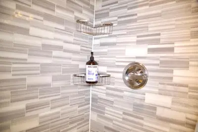 a bottle of wine on a shelf in a bathroom at New York Style Stay near Central Park in New York