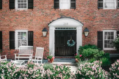 a brick house with two chairs and a black door at The Ellery in Northampton