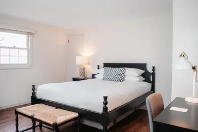 a bedroom with a bed with a desk and a chair at The Ellery in Northampton