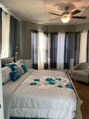 a bedroom with a large bed with a ceiling fan at Classic King Suite Apartment in Schenectady
