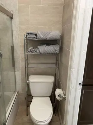 a small bathroom with a toilet and towels at Classic King Suite Apartment in Schenectady