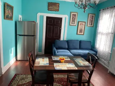 a blue living room with a table and a blue couch at Classic King Suite Apartment in Schenectady