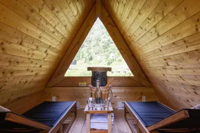 a room with two chairs and a window in a log cabin at Eastwind Hotel Oliverea Valley in Big Indian