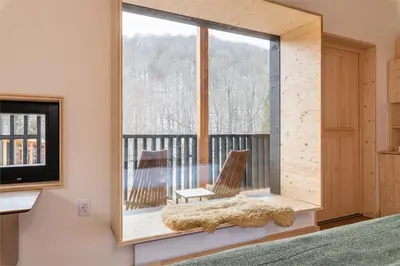 a room with a window with two chairs and a television at Eastwind Hotel Oliverea Valley in Big Indian