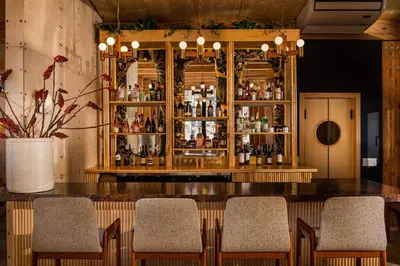 a bar with chairs and a counter with bottles at Eastwind Hotel Oliverea Valley in Big Indian