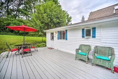a deck with a table and chairs and an umbrella at Cozy Milford Cottage on Half Acre w Deck & Grill in Milford