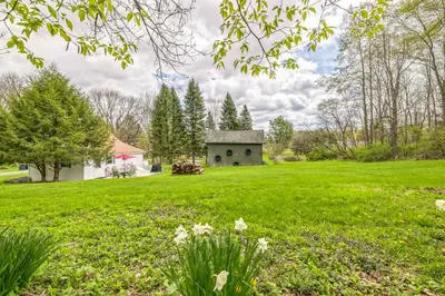 a green field with a house in the distance at Cozy Milford Cottage on Half Acre w Deck & Grill in Milford