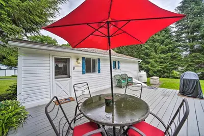 a table with a red umbrella on a patio at Cozy Milford Cottage on Half Acre w Deck & Grill in Milford