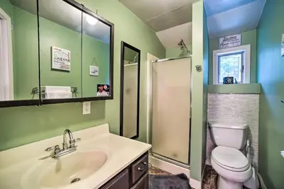 a bathroom with a sink and a toilet and a mirror at Cozy Milford Cottage on Half Acre w Deck & Grill in Milford