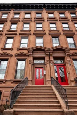 a building with a red door and stairs in front at New York City Guest House in New York