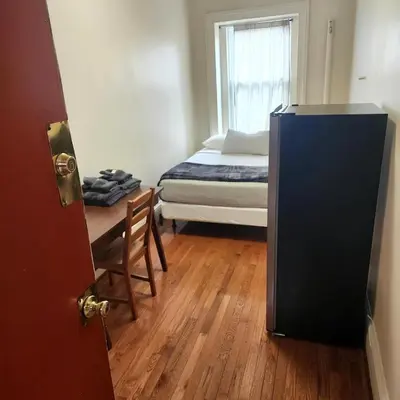 a room with a bed and a desk and a bed sidx sidx sidx at New York City Guest House in New York