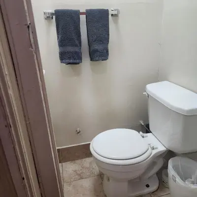 a bathroom with a white toilet and blue towels at New York City Guest House in New York