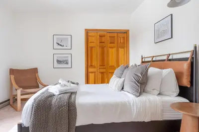 a bedroom with a bed and a wooden door at 8BR Luxury Maplewood Manor, Hot Tub & Fire Pit in Jewett