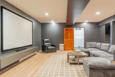 a living room with a large flat screen tv at 8BR Luxury Maplewood Manor, Hot Tub & Fire Pit in Jewett
