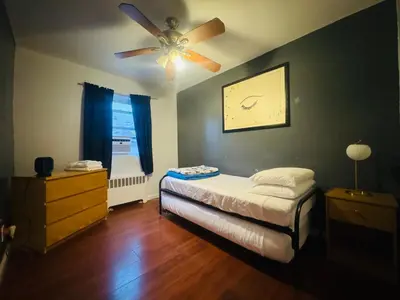 a bedroom with a bed and a ceiling fan at The Pink Paradise in Bronxdale