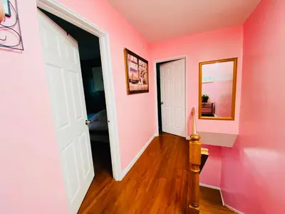 a hallway with pink walls and a white door at The Pink Paradise in Bronxdale