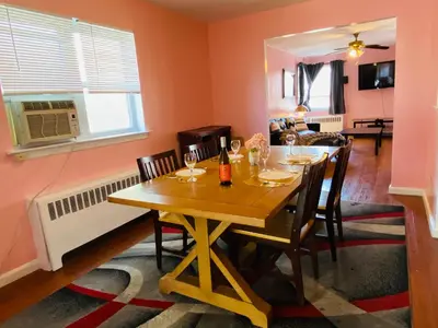 a dining room with a wooden table and chairs at The Pink Paradise in Bronxdale