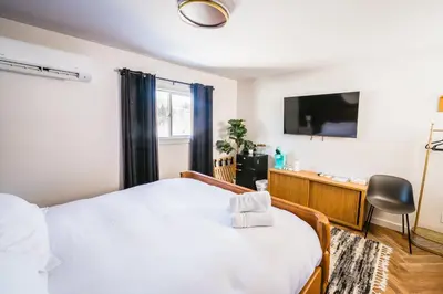 a bedroom with a white bed and a tv at Chalet 239-Boutique Hotel in West Dover