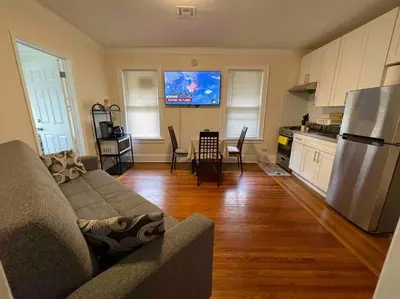 a living room with a couch and a kitchen at Entire Cozy 1BR Apartment in heart of Queens L in Whitestone
