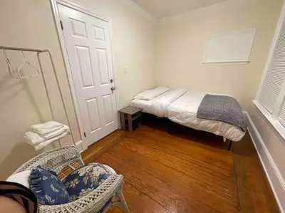 a room with a bed and a chair and a door at Entire Cozy 1BR Apartment in heart of Queens L in Whitestone