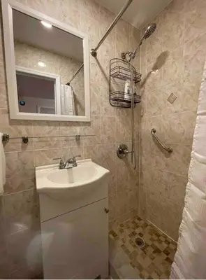 a bathroom with a sink and a shower with a mirror at Entire Cozy 1BR Apartment in heart of Queens L in Whitestone