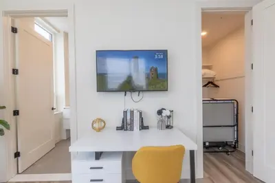 a room with a white desk and a yellow chair at Bright and Bold Escape with NYC Views and Free Parking, Sleeps 9 and 2 Baths in Newark