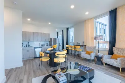 a kitchen and living room with a table and chairs at Bright and Bold Escape with NYC Views and Free Parking, Sleeps 9 and 2 Baths in Newark