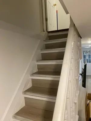 a staircase in a house with a white railing at Cozy Apartments Woodside near Manhattan in Queens