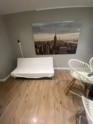 a bedroom with a white bed and a view of a city at Cozy Apartments Woodside near Manhattan in Queens
